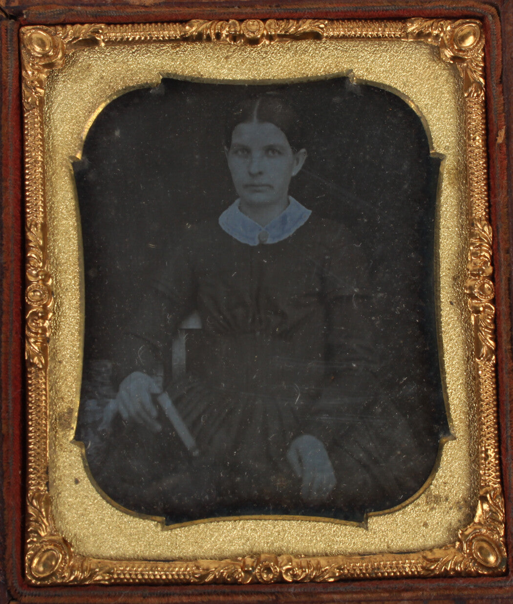 WOMAN HOLDING BOOK, UNPLEASANT EXPRESSION. 6TH PLATE DAGUERREOTYPE, FILL CASE.