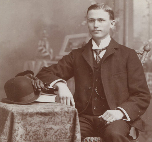 YOUNG MAN SEATED AT TABLE, BOOKS, GLOVES AND BOWLER HAT. CABINET CARD, KANSAS.