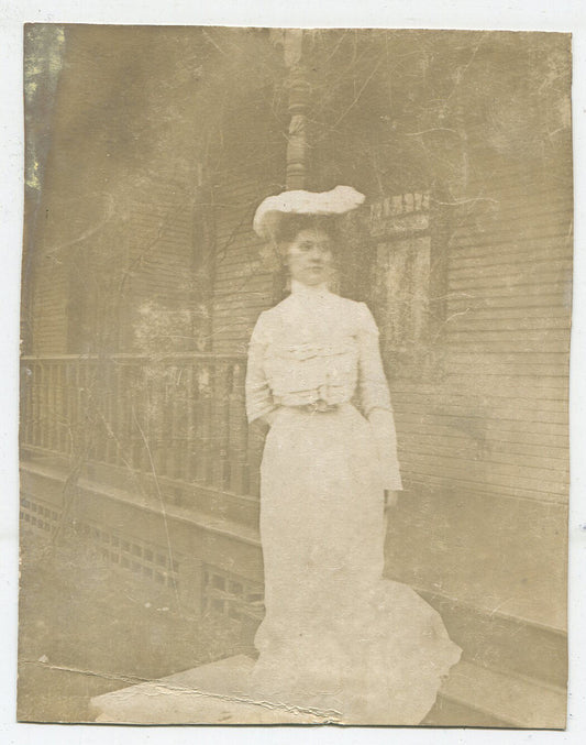 WOMAN IN CLASSIC 1900 DRESS AND HAT. OUTDOOR PHOTO. VINTAGE TONED B W PHOTO.