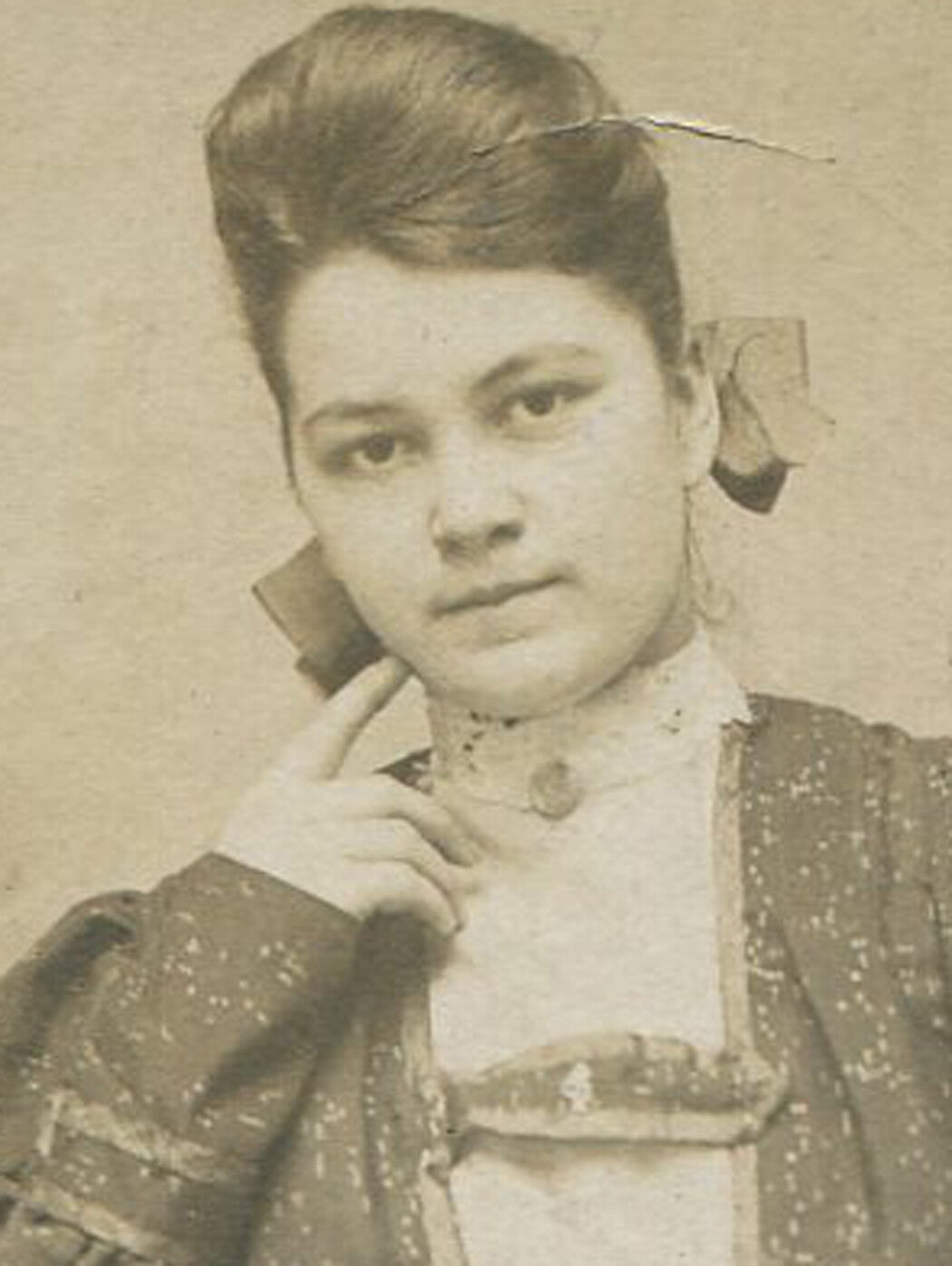WOMAN WITH HAIR PILED HIGH. RELAXED POSE, FINGER ON CHIN. LATE CABINET CARD.