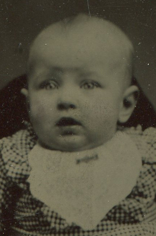 BAREFOOT BABY POSED ON CHAIR. TINTYPE IN PERIOD PAPER MAT.