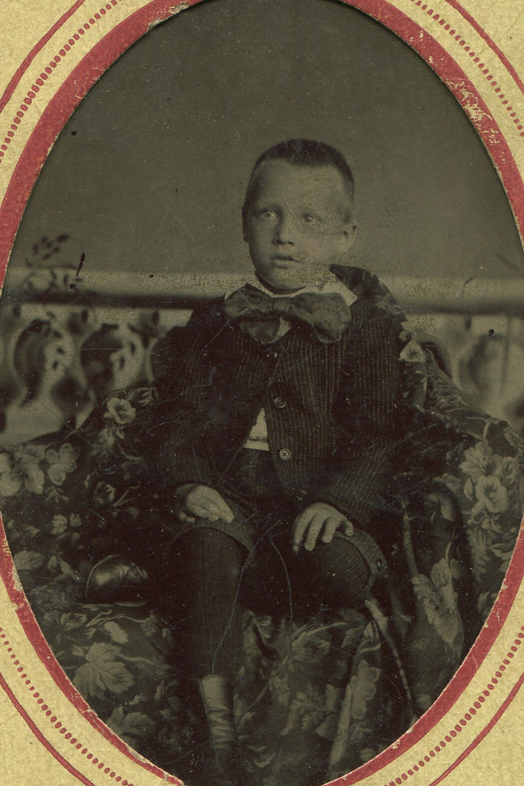 BOY W/ BUZZ CUT HAIR, BIG BOW TIE. TINTYPE IN PERIOD PAPER MAT.
