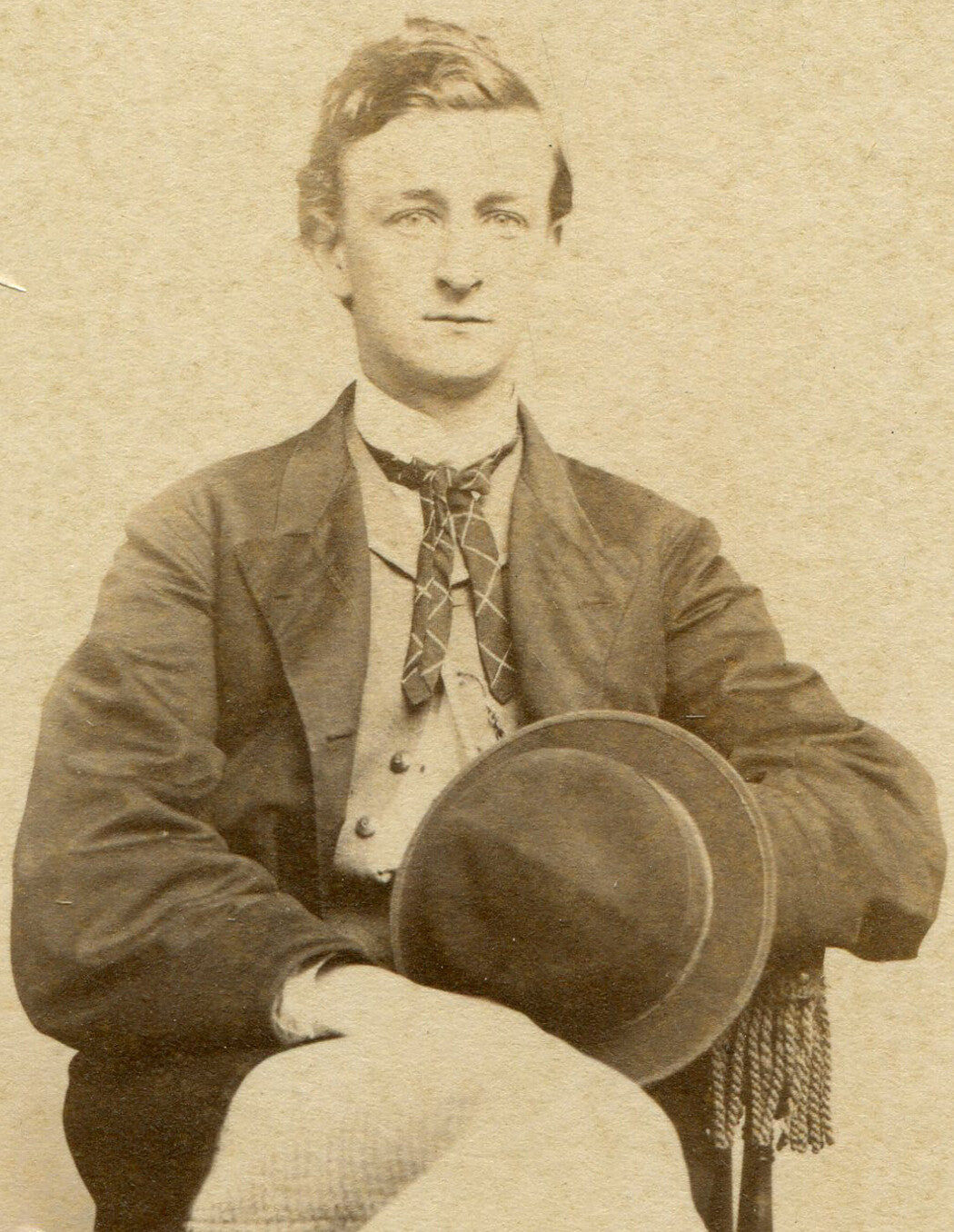 MAN POSED HOLDING HAT, SEATED WITH LEGS CROSSED. CDV.