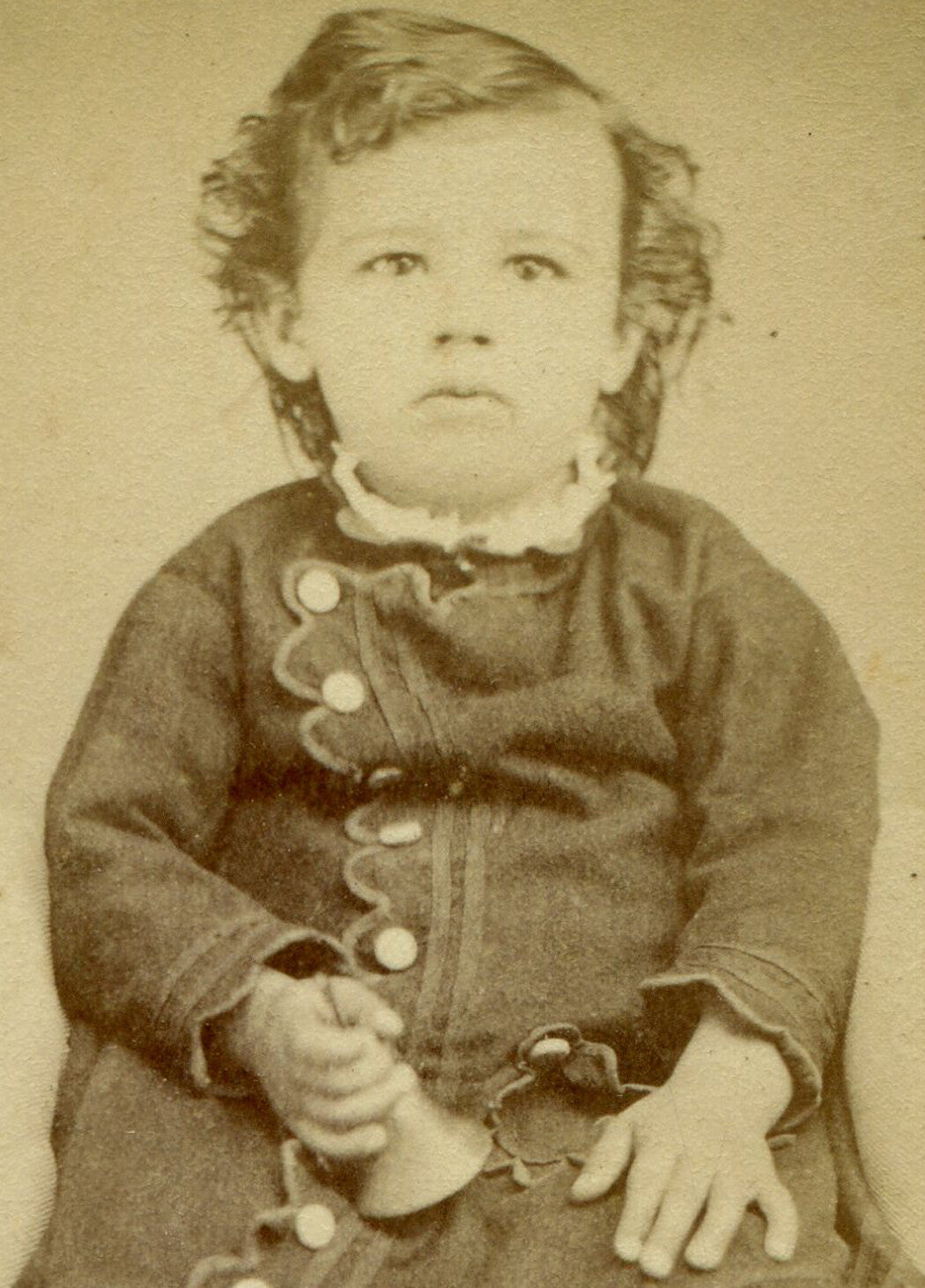 CHILD POSED HOLDING BELL TOY. CDV.