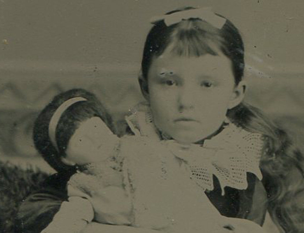 LITTLE GIRL POSED HOLDING BABY DOLL. TINTYPE.