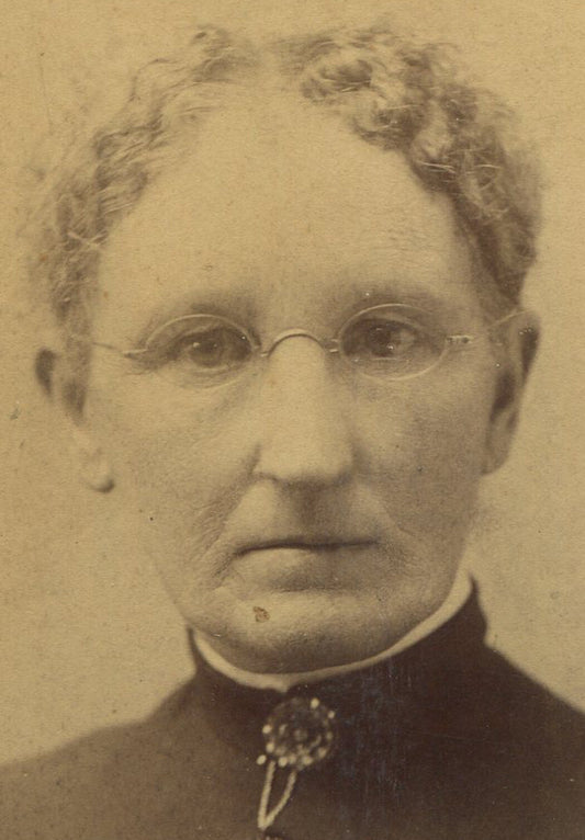WOMAN W/EYEGLASSES, CRIMPED HAIR AND COLLAR PIN. CABINET CARD.