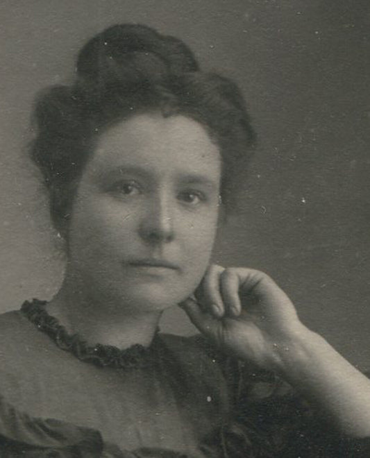 WOMAN W, HAND AT CHIN, RUFFLE DRESS. TONED PRINT.
