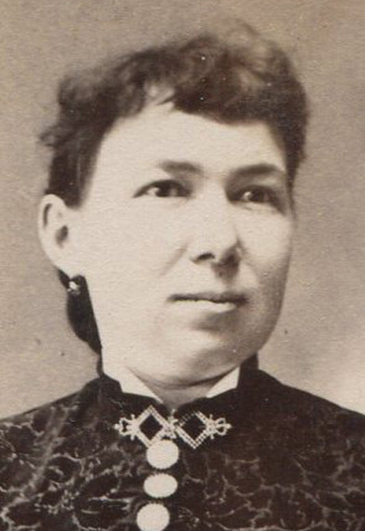 WOMAN, STIFFLY POSED IN COMPLICATED DRESS. CABINET CARD.