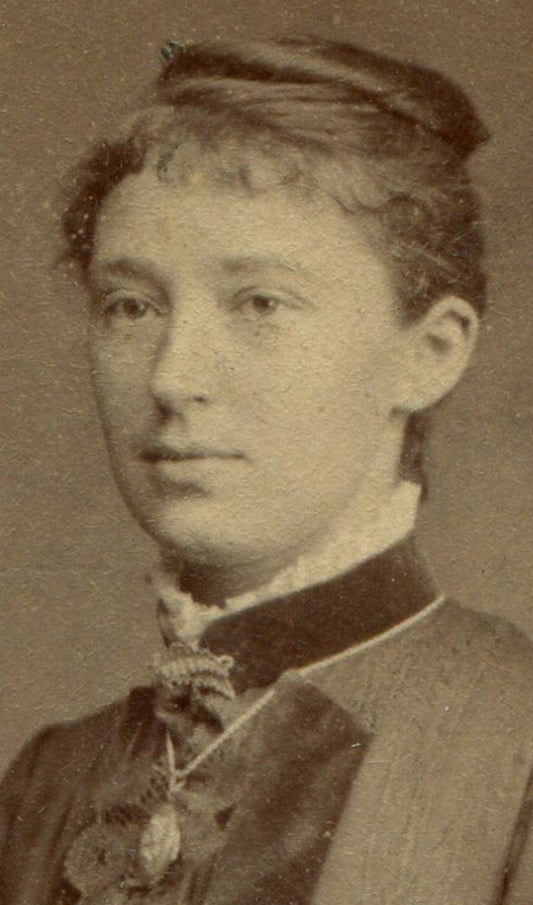 WOMAN POSED LEANING ON CHAIR, HOLDING FLOWER. CDV.