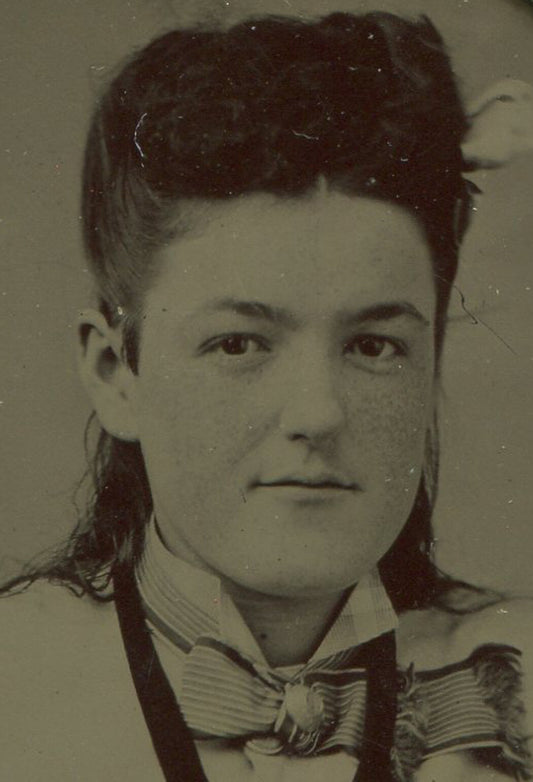 WOMAN SEATED POSE, CROSSED ARMS, HIGH HAIR. TINTYPE IN PERIOD PAPER MAT.
