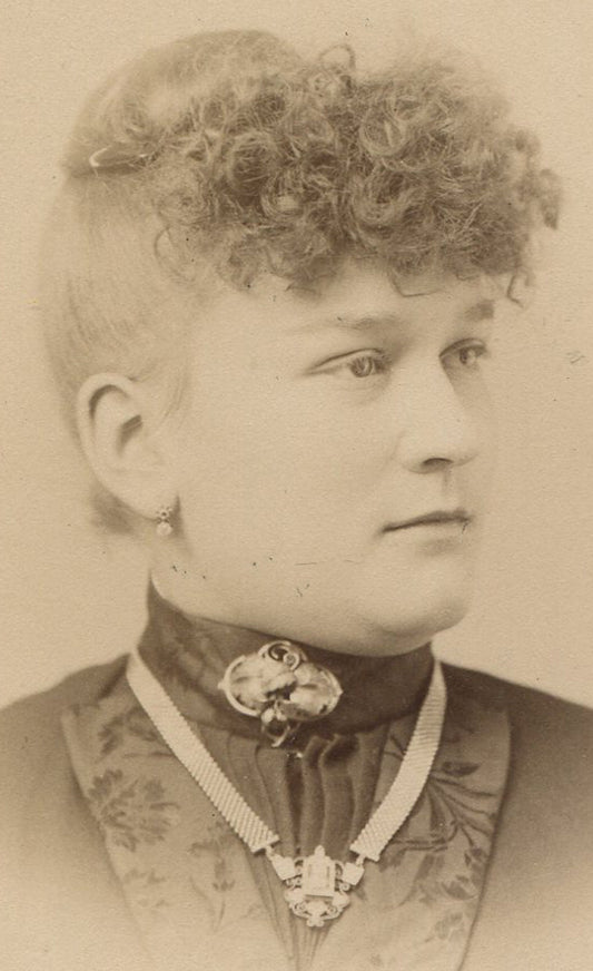 WOMAN ROCKING SEVERELY POUFFY BANGS, JEWELRY. CABINET CARD, NICKERSON, MICHIGAN.