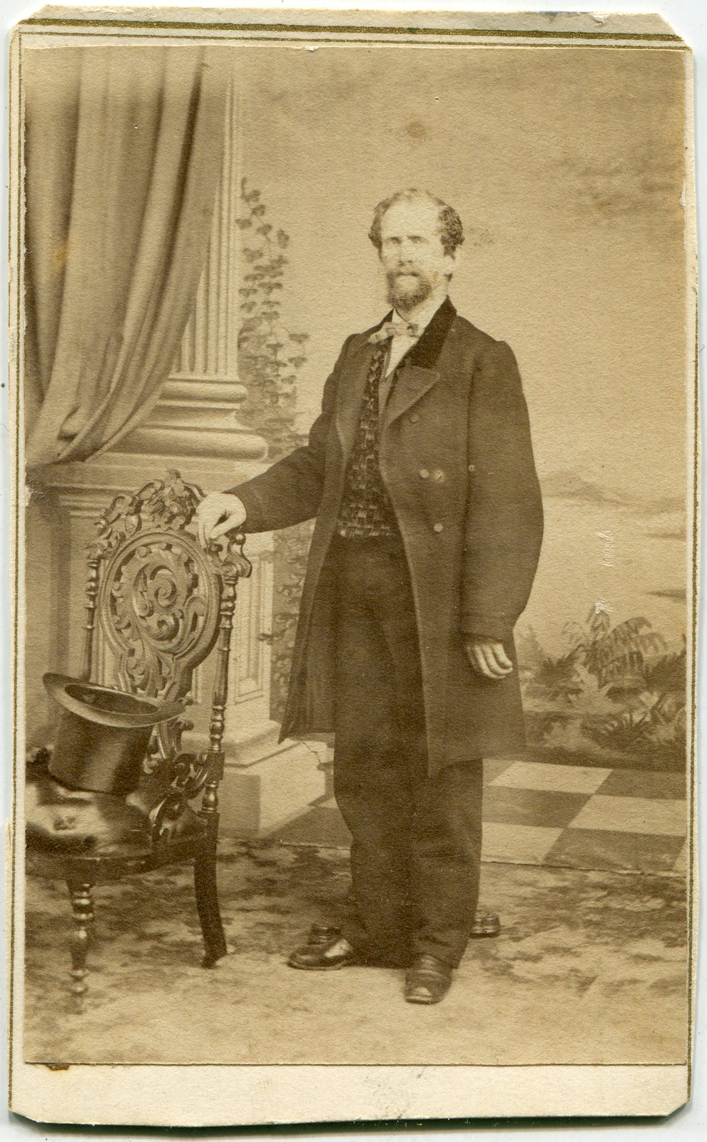 MAN STANDING AT CHAIR, HAT ON SEAT. PAINTED BACKGROUND. CDV. SAN FRANCISCO, CA.