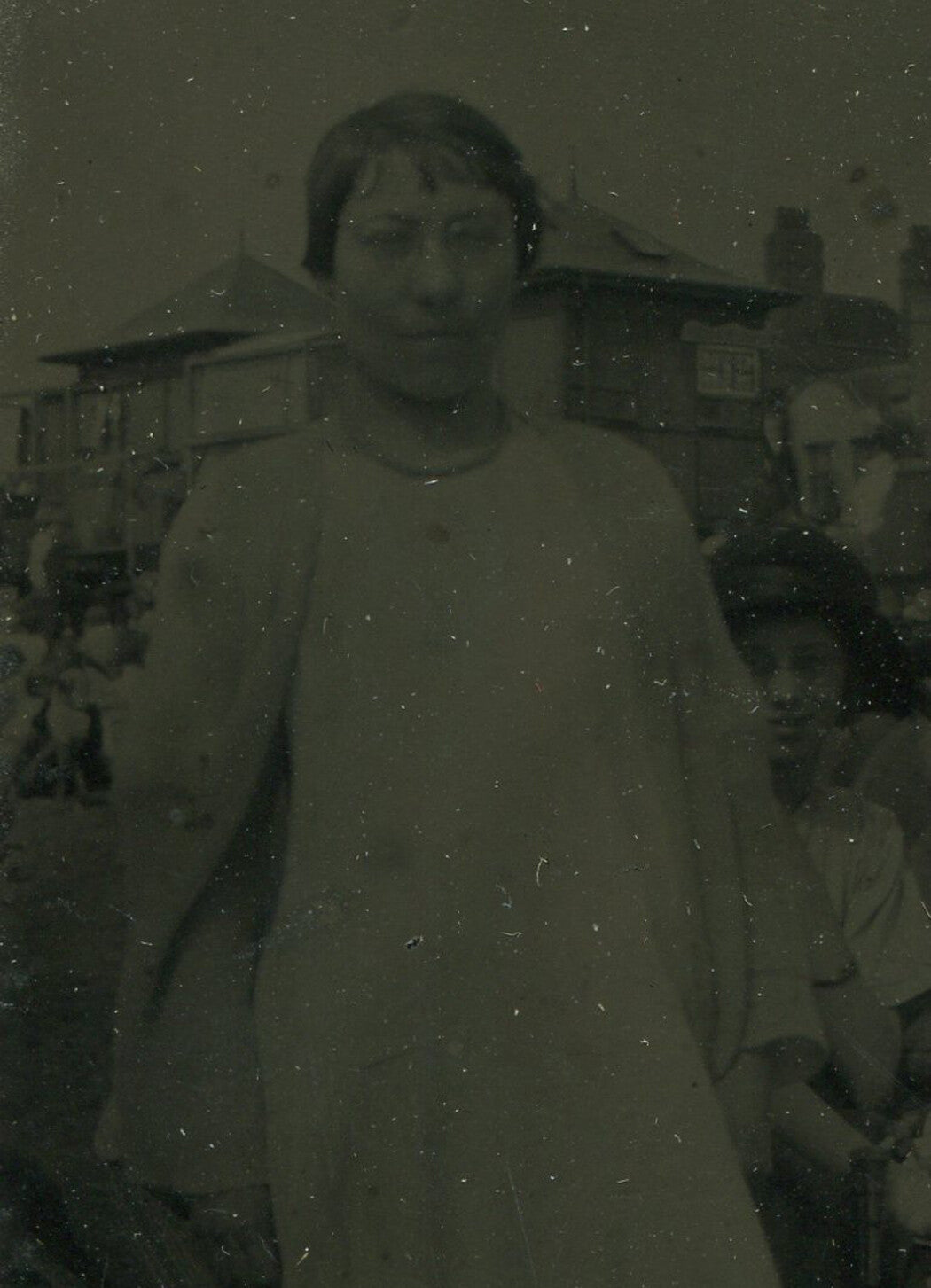 WOMAN IN GLASSES. BACKGROUND HAS A STORY TO TELL. TINTYPE IN ORNATE MAT.