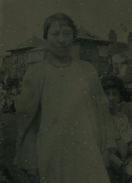 WOMAN IN GLASSES. BACKGROUND HAS A STORY TO TELL. TINTYPE IN ORNATE MAT.