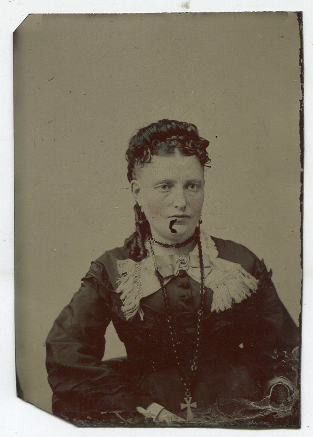 BEADY EYED WOMAN WITH STIFF LOOKING CURLS. TINTED TINTYPE.