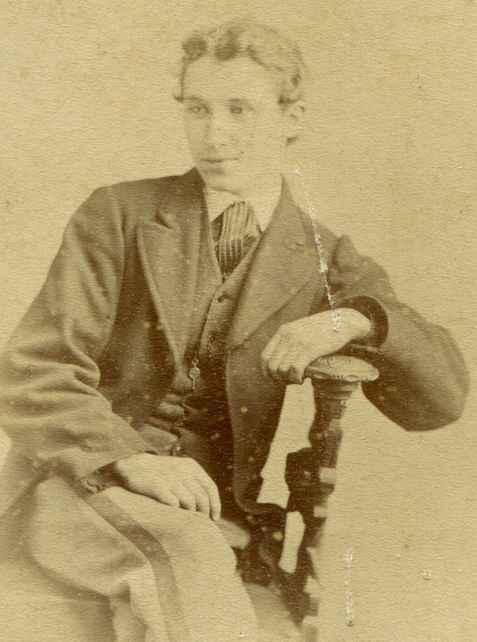 YOUNG MAN IN CASUAL SEATED POSE. GLASGOW, SCOTLAND.