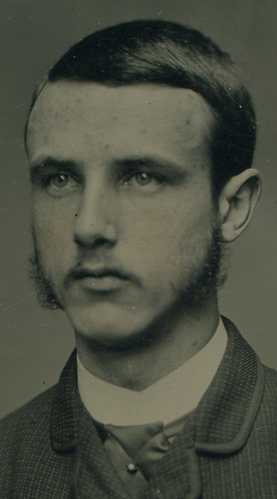 YOUNG MAN STRUGGLES TO GROW BEARD. TINTED TINTYPE IN PERIOD PAPED MAT.
