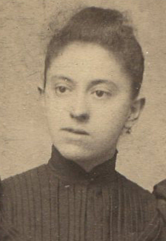 WOMAN, BLANK STARE, POSED AT TABLE WITH BOOKS AND FLOWERS. CABINET CARD.