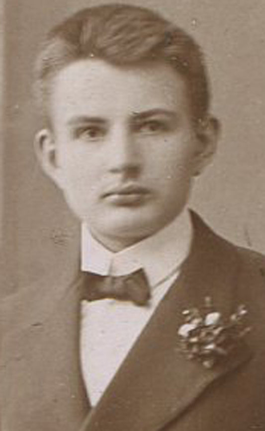 YOUNG MAN HOLDING BOOK, BOWLER HAT ON TABLE. TONED SILVER PRINT, CIRCA 1900.