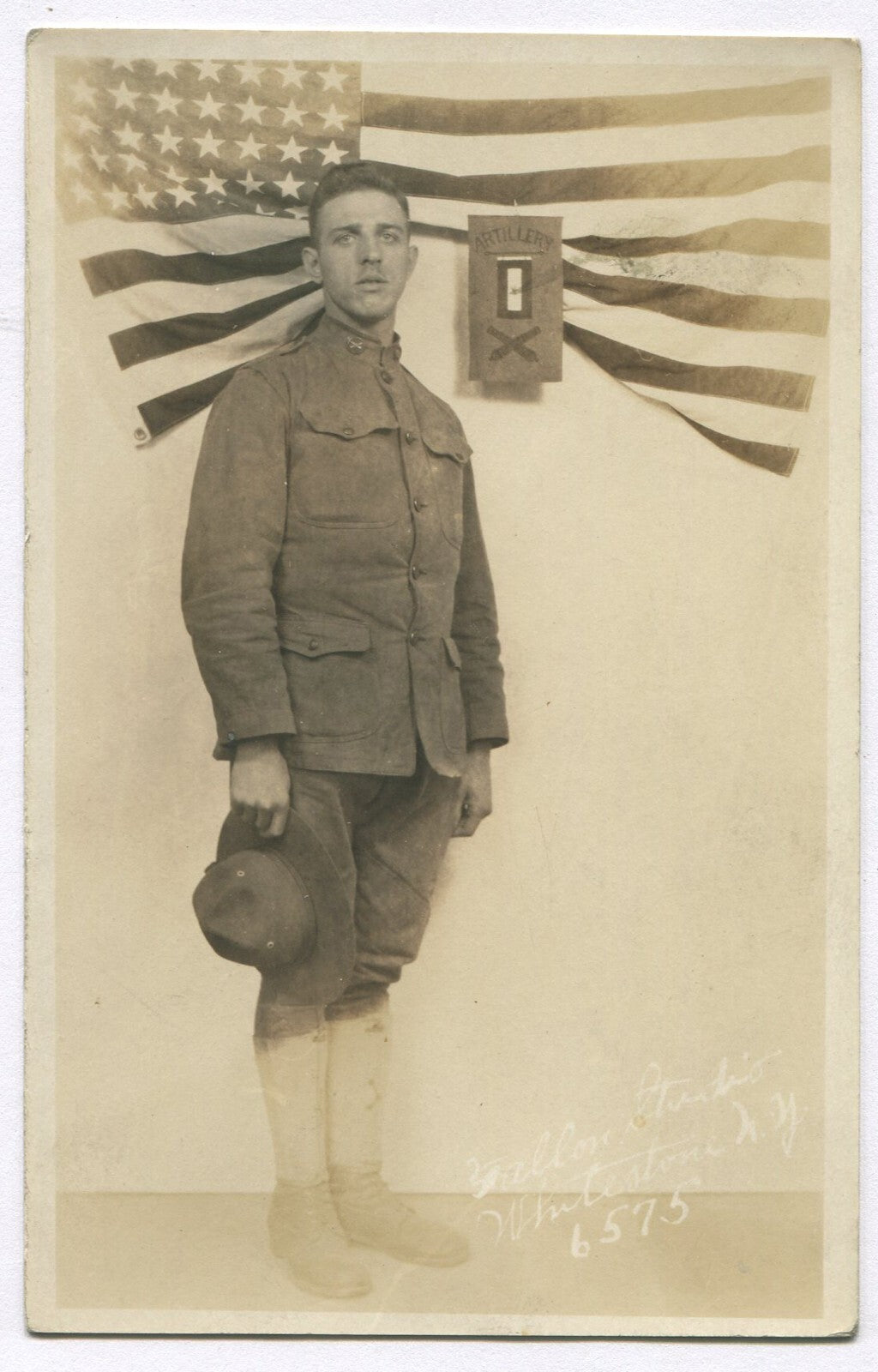 WWI SOLDIER IN UNIFORM POSED W/FLAG. PHOTO POSTCARD.