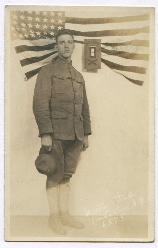WWI SOLDIER IN UNIFORM POSED W/FLAG. PHOTO POSTCARD.