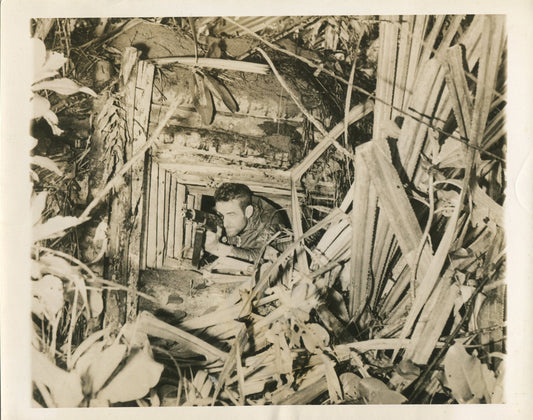 U.S.SOLDIER IN CAPTURED JAPANESE MACHINE GUN NEST. NEW GUINEA WWII(8X10 REPRINT)