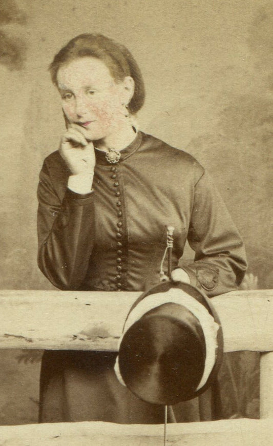 WOMAN IN RELAXED POSE HOLDING HAT, LEANING ON FENCE GATE. CDV. BRIGHTON, ENGLAND
