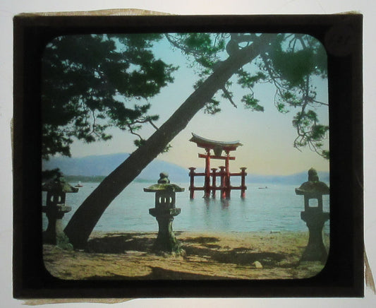 TRADITIONAL JAPANESE MEMORIAL AT WATERS EDGE. HAND COLORED PHOTO ON GLASS.