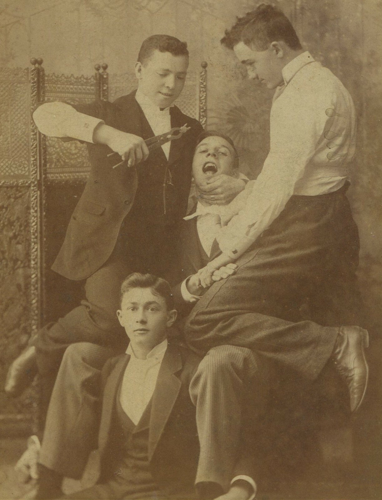 YOUNG MEN ENGAGED IN TOOTH EXTRACTION, COMICAL. CABINET CARD. BUTLER, PA.