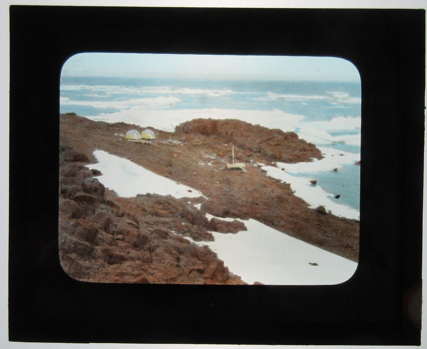 TENTS ON ROCKY SHORE, BY ICY OCEAN. TINTED LANTERN SLIDE.