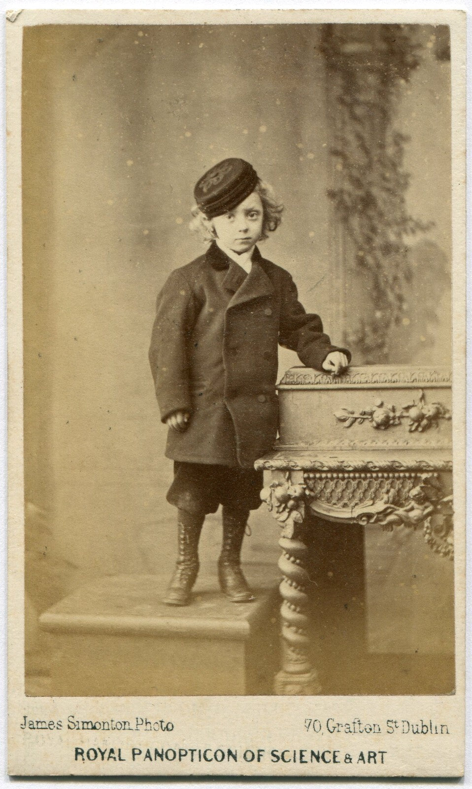 YOUNG BOY WITH WAVY HAIR, HIGH BOOTS AND WOOL HAT. CDV, DUBLIN, IRELAND.