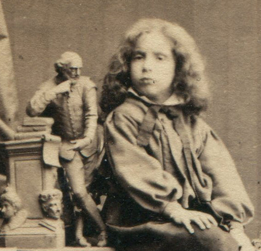 CHILD POSED WITH SMALL STATUE. WHIMSICAL STUDIO SETTING. CDV. LONDON.