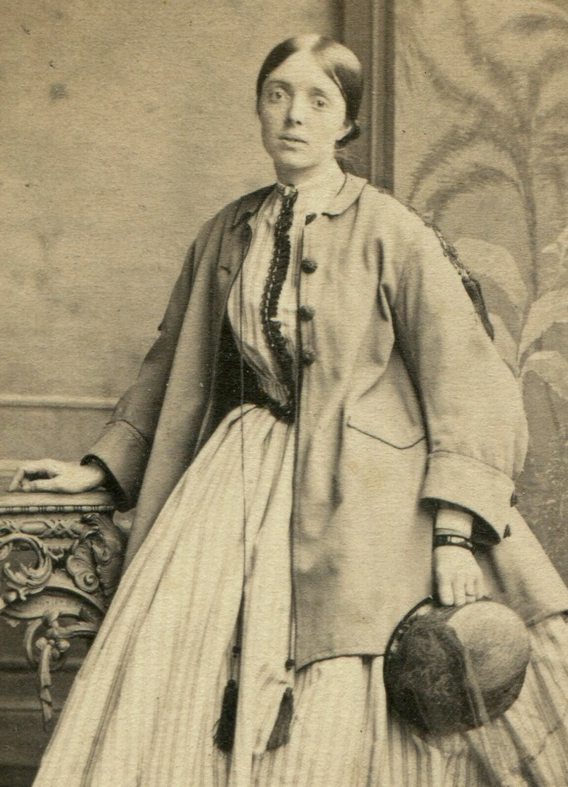 SAD EYED WOMAN POSED IN OVERCOAT HOLDING HAT. CDV. HASTINGS, ENGLAND.