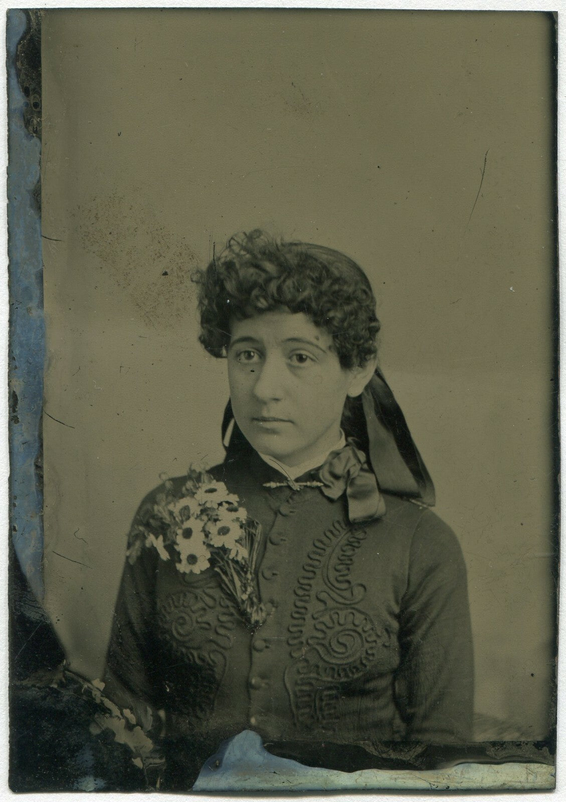 YOUNG WOMAN WITH CURLY BANGS, BIG FLOWER PIN. TINTED TINTYPE.