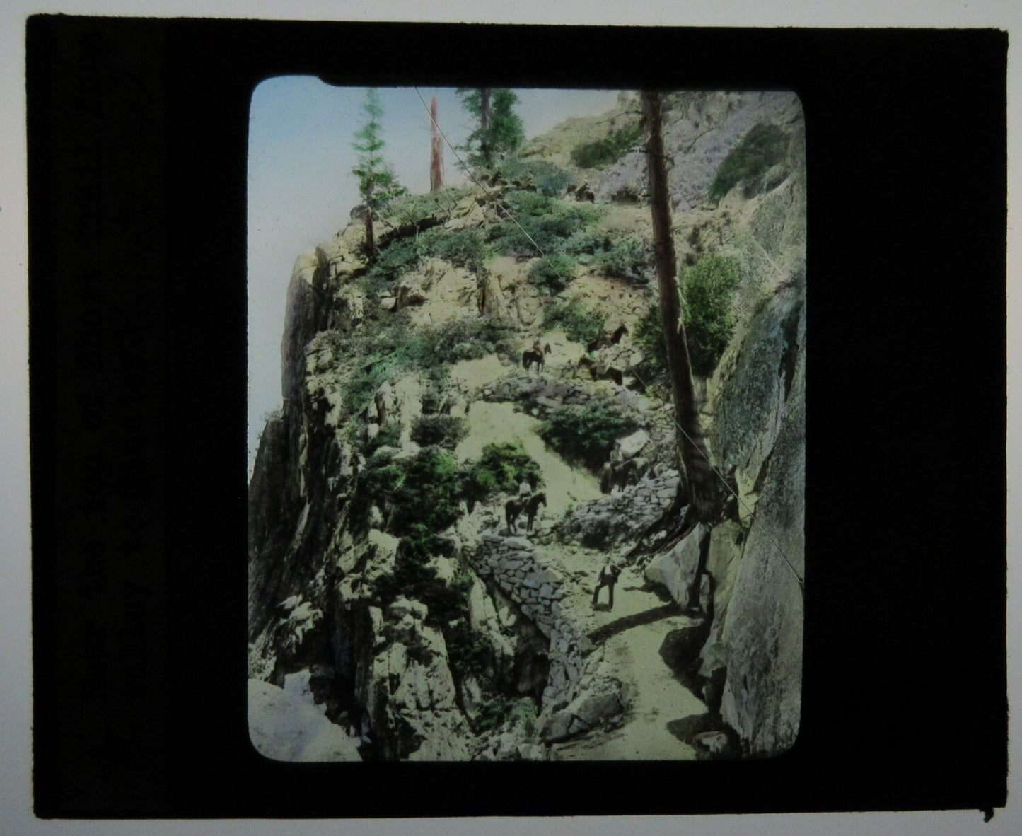 Vintage tinted lantern slide: People on horseback at Glacier Point Trail, Yosemite, photo on glass 3x3.5 in