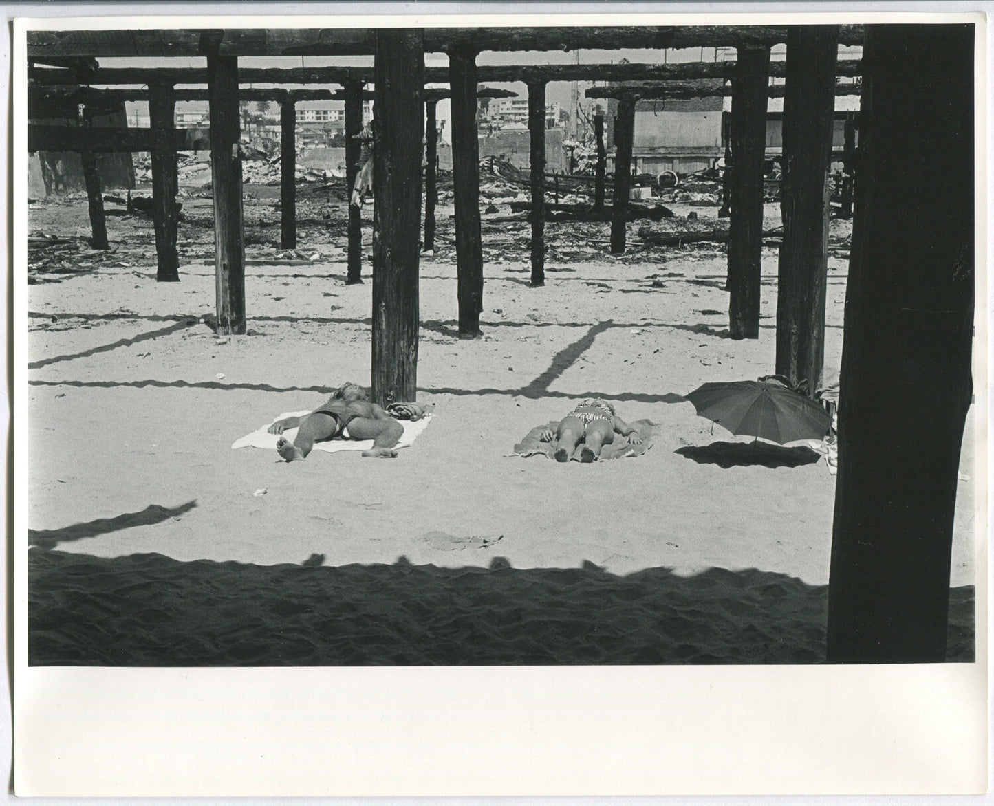 YOUNG COUPLE SUNBATHING, PIER SHADOWS. B&W 8X10.1970s B&W 8x10
