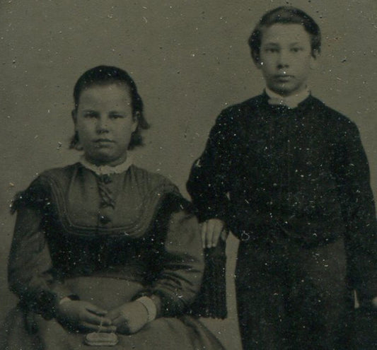YOUNG SIBLINGS. GIRL W/PURSE, BOY HOLDING HAT. TINTYPE IN PERIOD PAPER MAT.