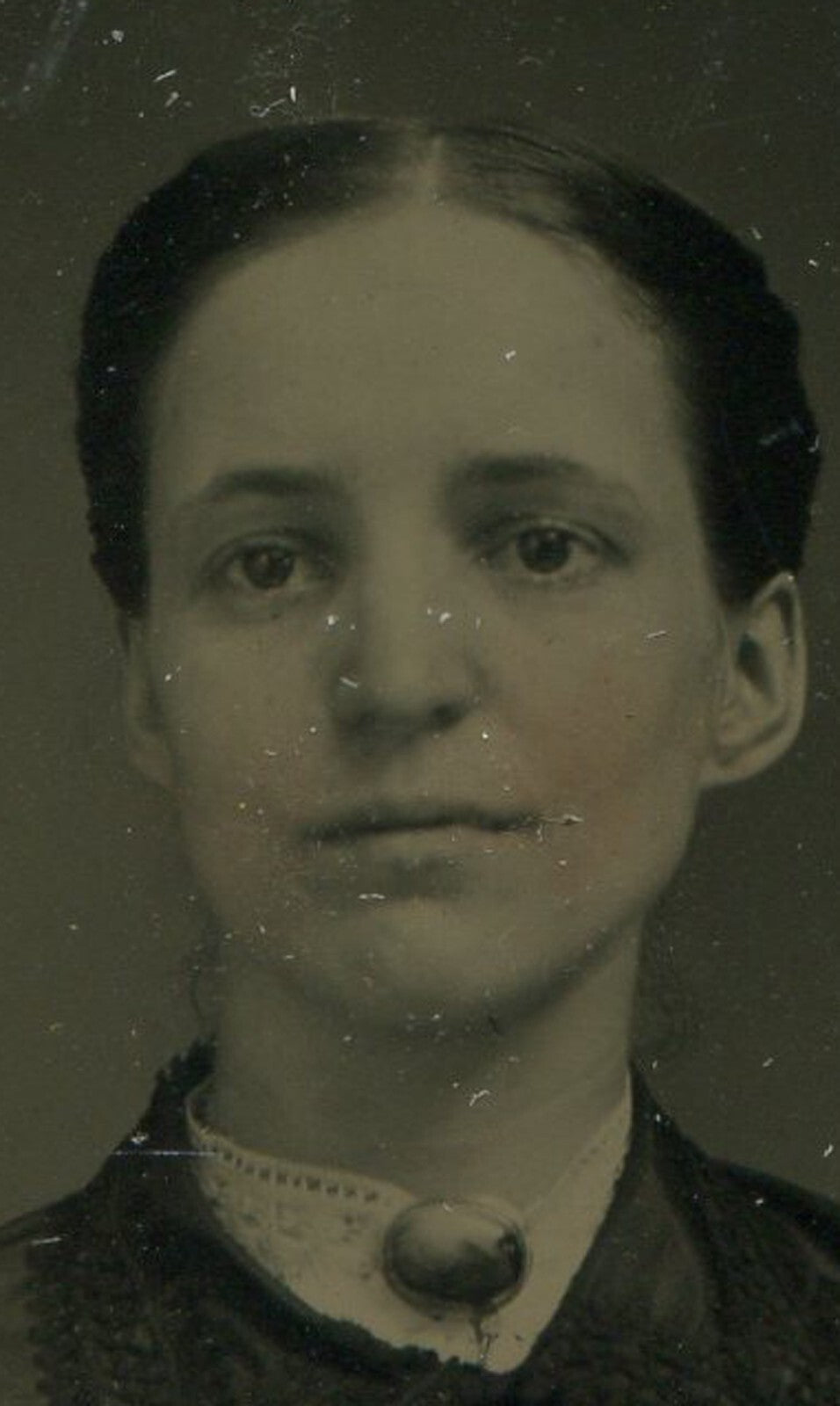 DARK HAIRED, SAD EYED WOMAN. TINTED TINTYPE IN PERIOD PAPER MAT.