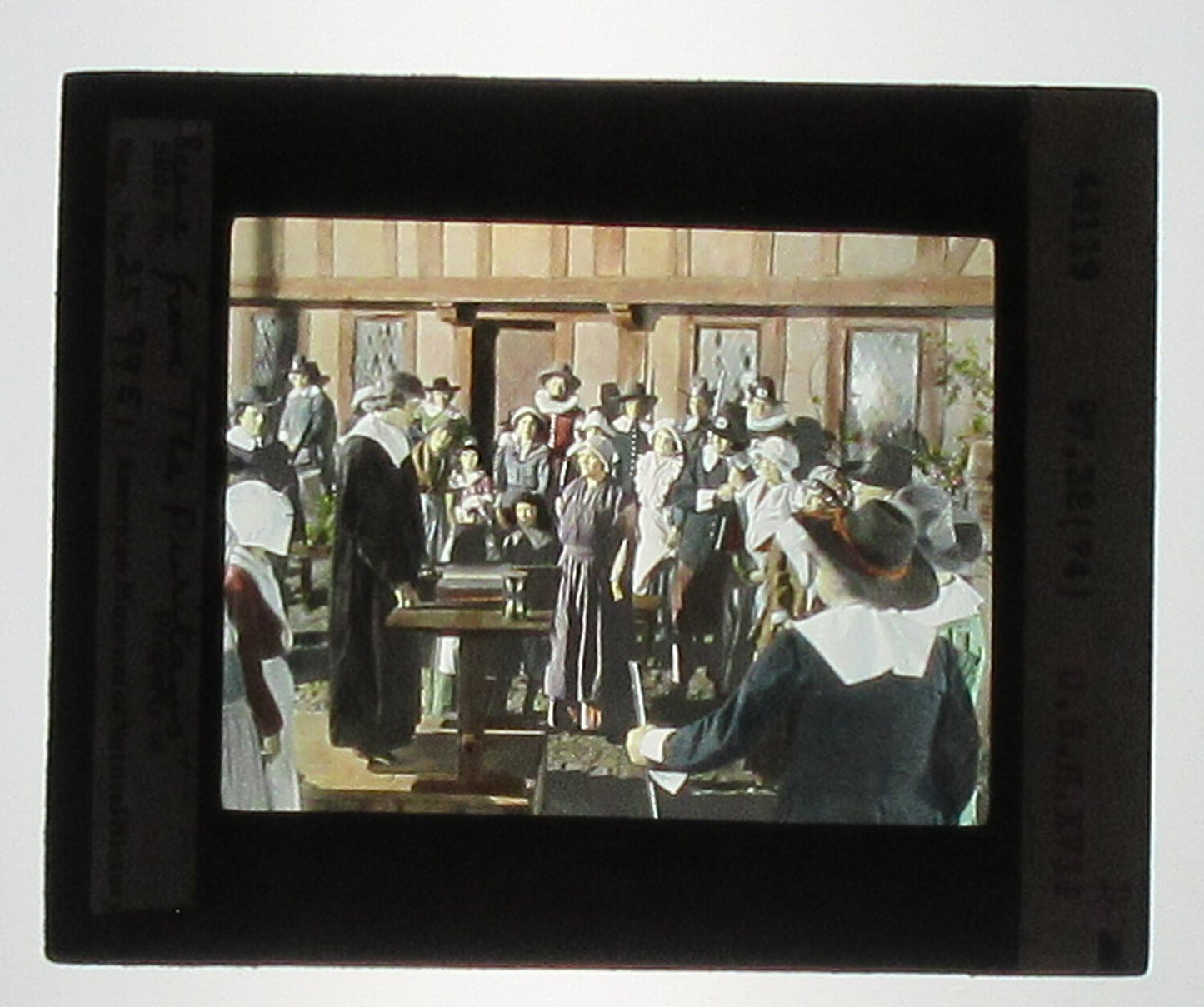 ACTORS PORTRAY JOHN COTTON/PURITANS. HAND COLORED PHOTO ON GLASS.