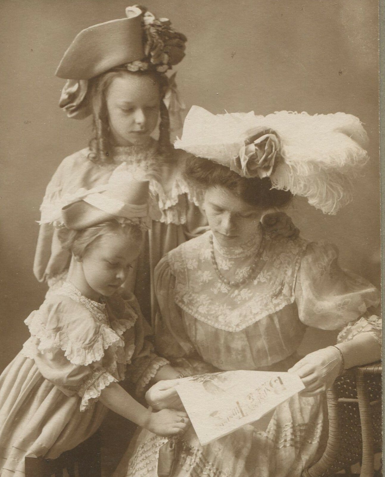 MOTHER W/DAUGHTERS IN VERY FANCY HATS. 5.25X3X5.5IN TONED SILVER PRINT.