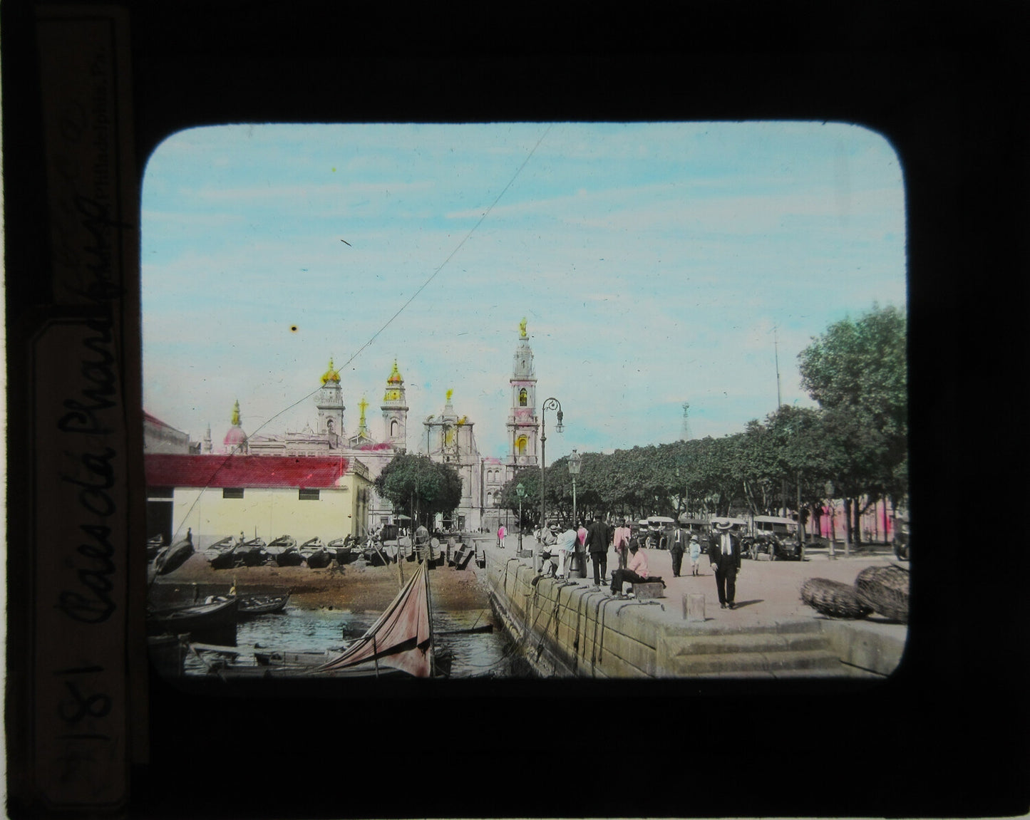 VIEW OF SMALL BOAT DOCK, CHURCH IN BACKGROUND. HAND COLORED PHOTO ON GLASS.