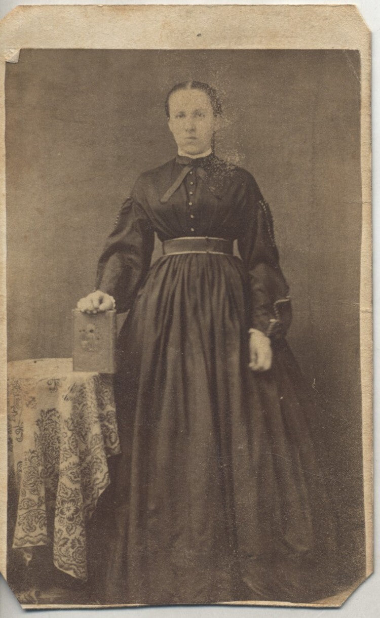 CDV OF STERN YOUNG WOMAN IN BEAUTIFUL DRESS HOLDING BOOK