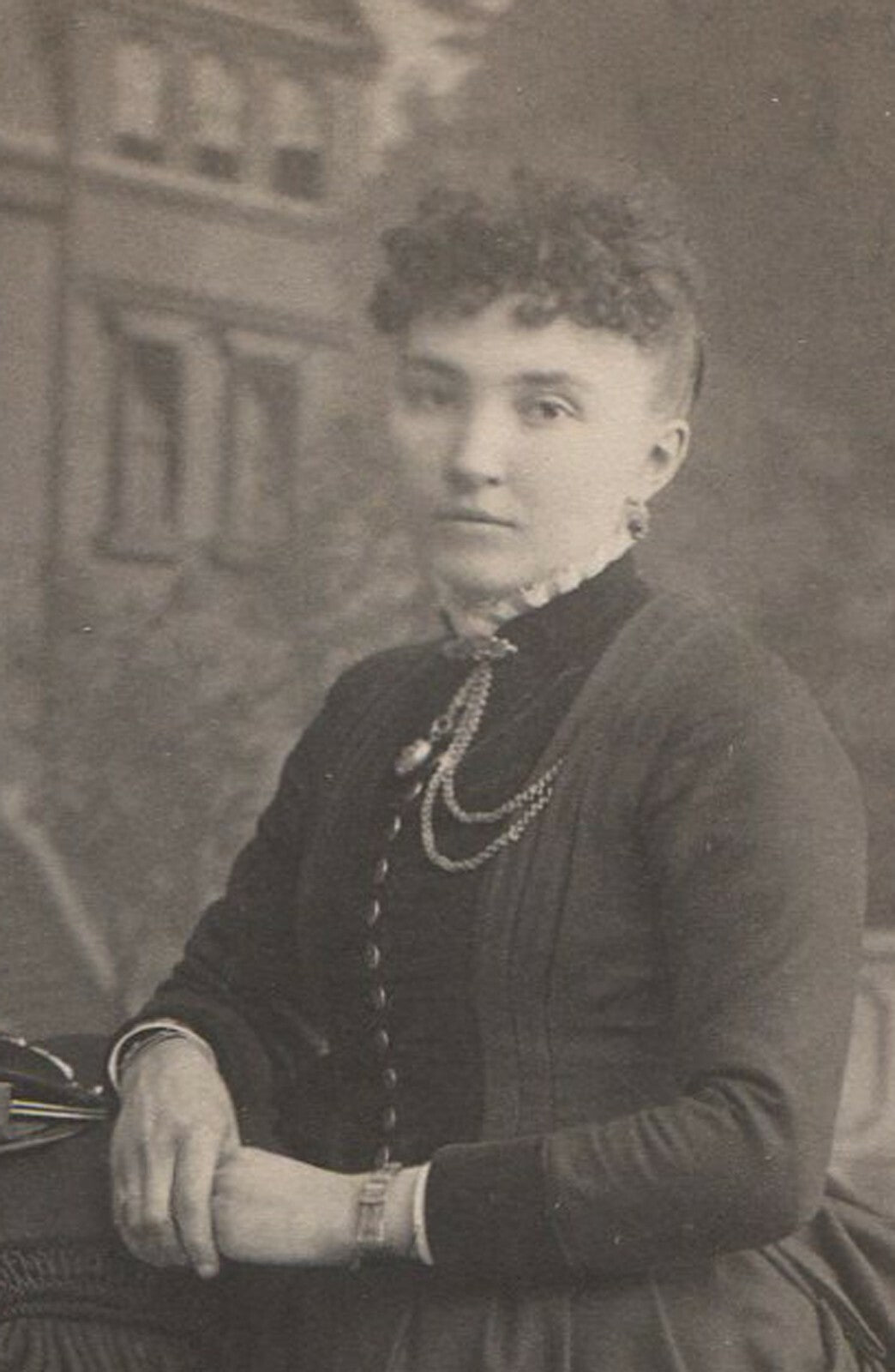 WOMAN POSED W/COAT AND HANDBAG. HOUSE IS PAINTED BACKGROUND. CABINET CARD. WIS.