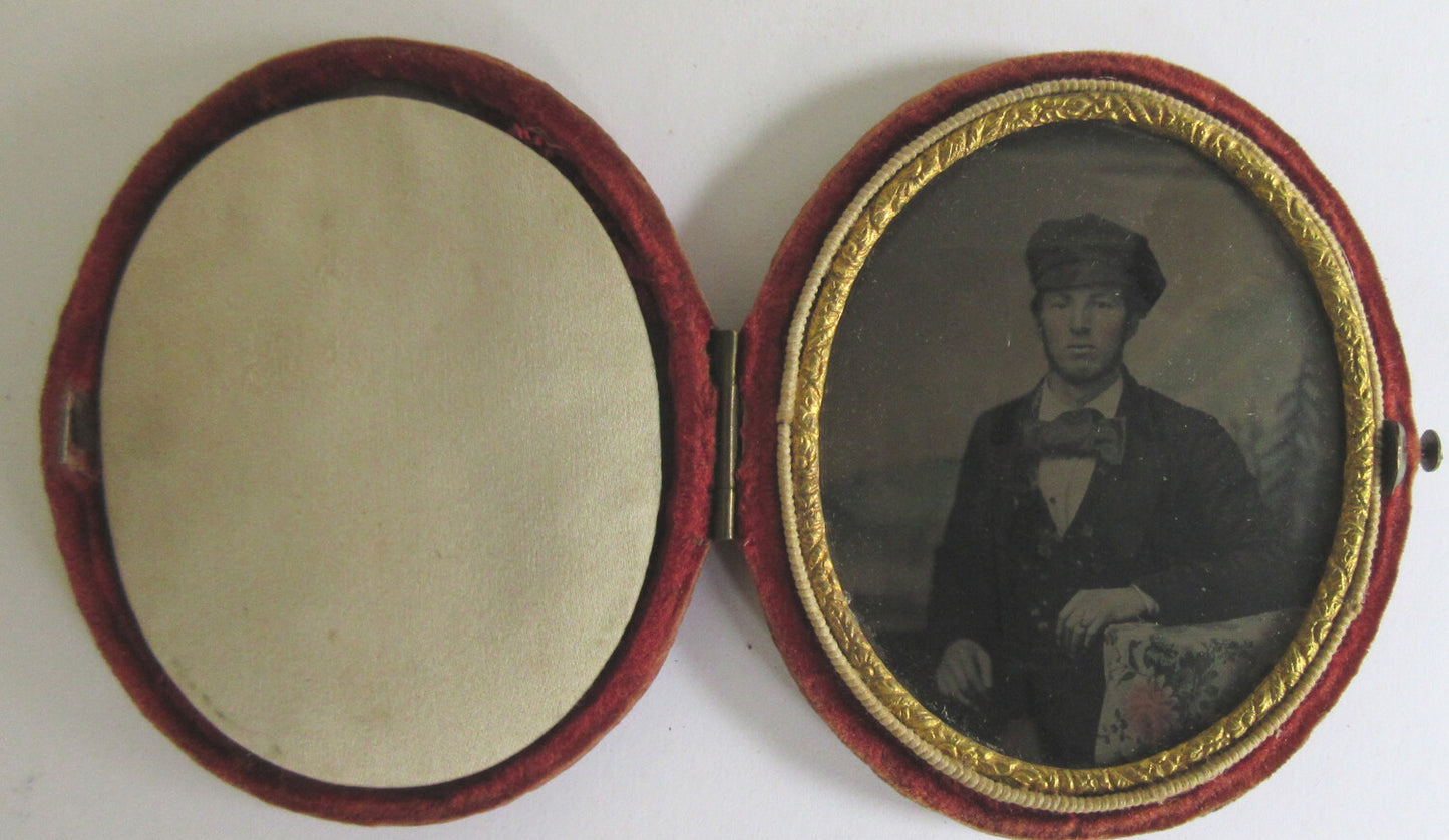 MAN,FISHERMAN CAP, BOW TIE. TINTED, PAINTED BACKGROUND, 9TH PLATE OVAL TINTYPE,