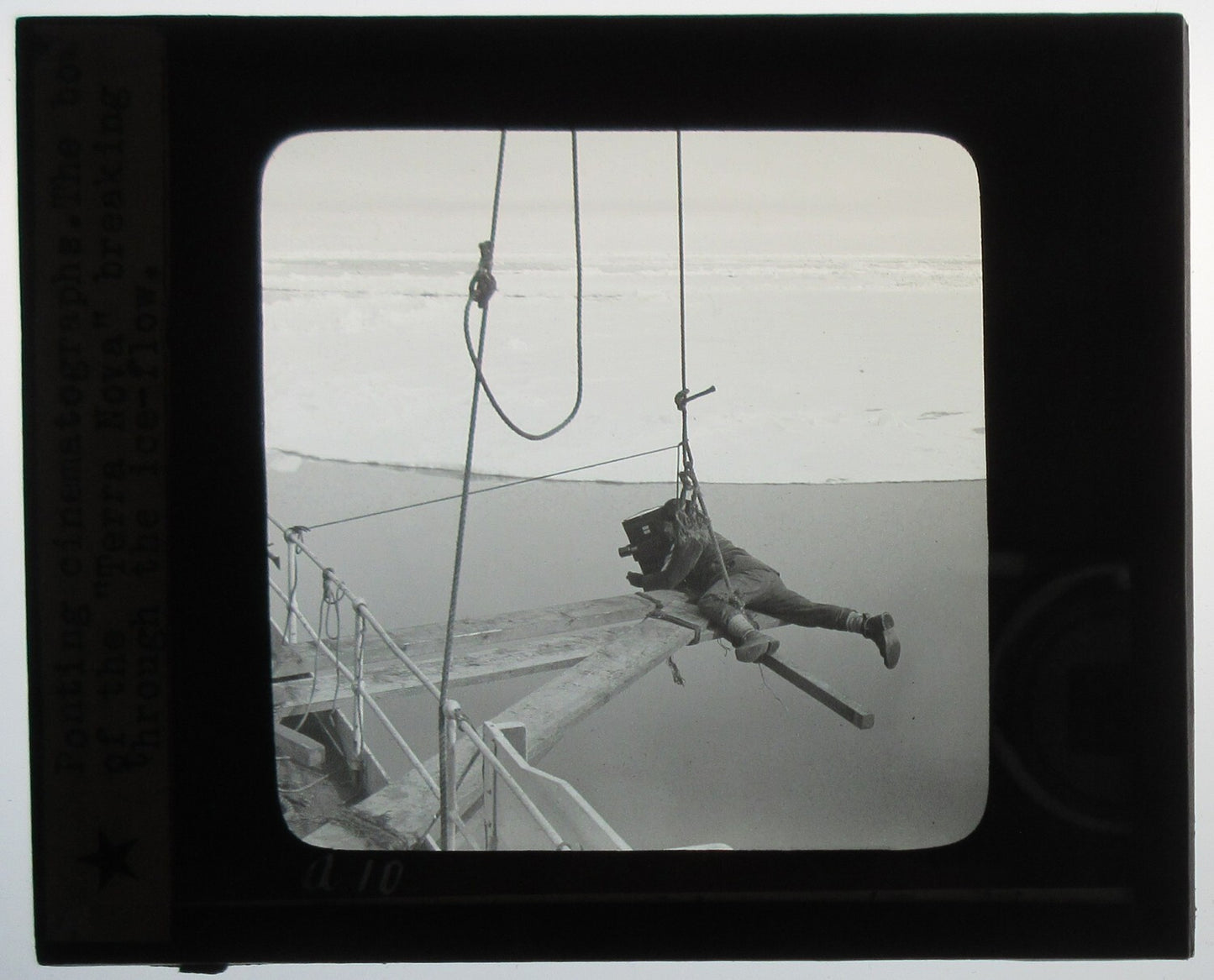 EARLY CINEMATOGRAPHY. MAN SUSPENDED ALOFT W/CAMERA ROLLING. PHOTO ON GLASS.