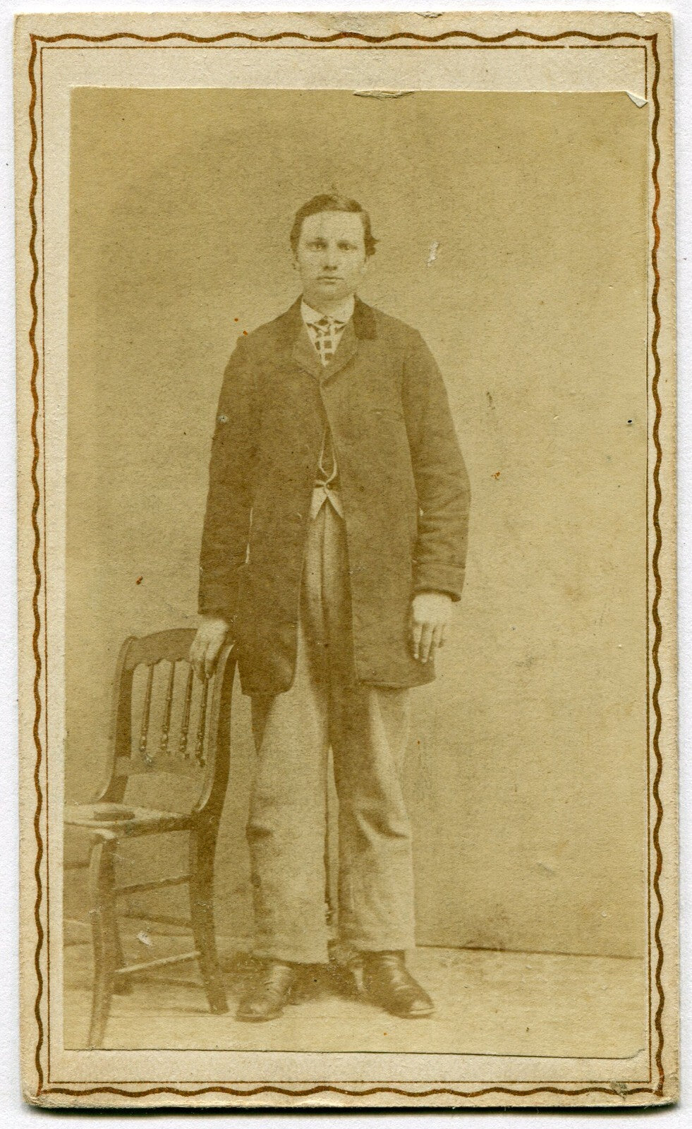 VERY TALL MAN, STANDING POSE, NEXT TO SMALL CHAIR. CDV.