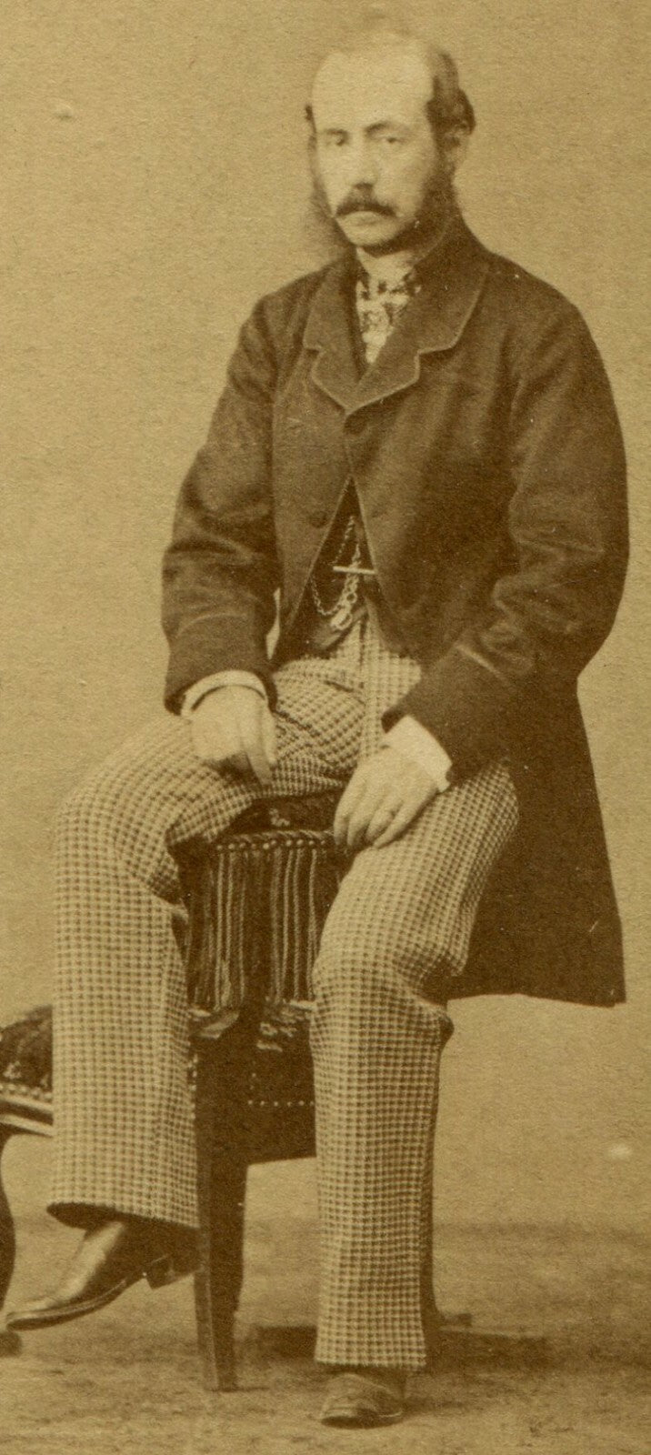 MAN UNCOMFORTABLY POSED ON CHAIR ARM. OUCH. CDV.