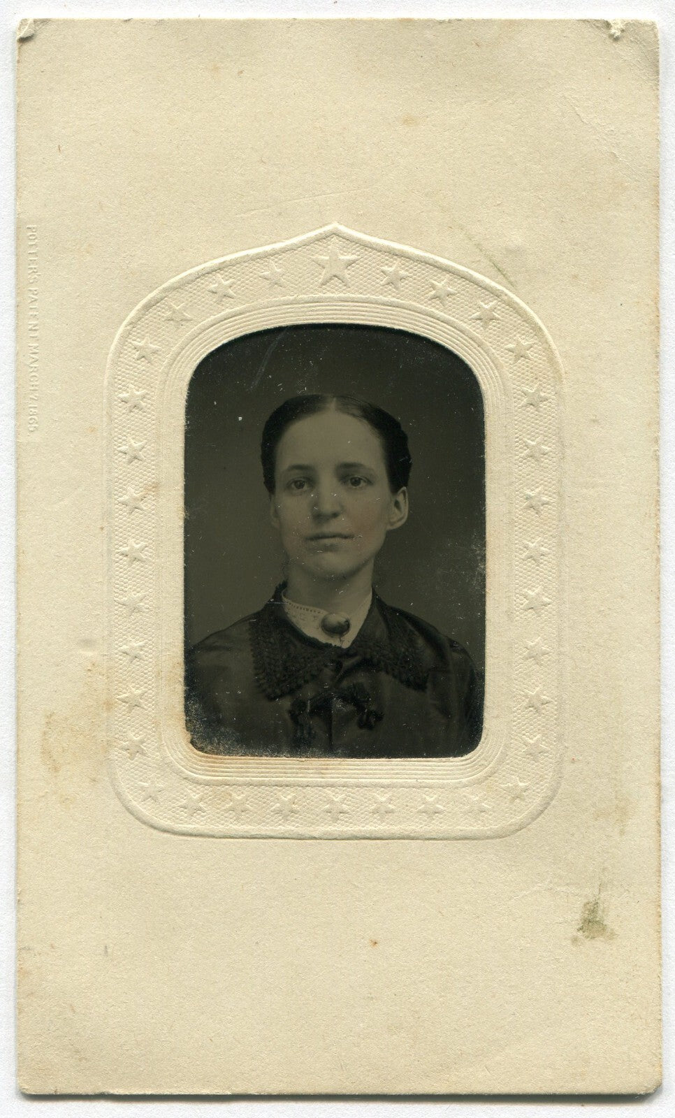 DARK HAIRED, SAD EYED WOMAN. TINTED TINTYPE IN PERIOD PAPER MAT.