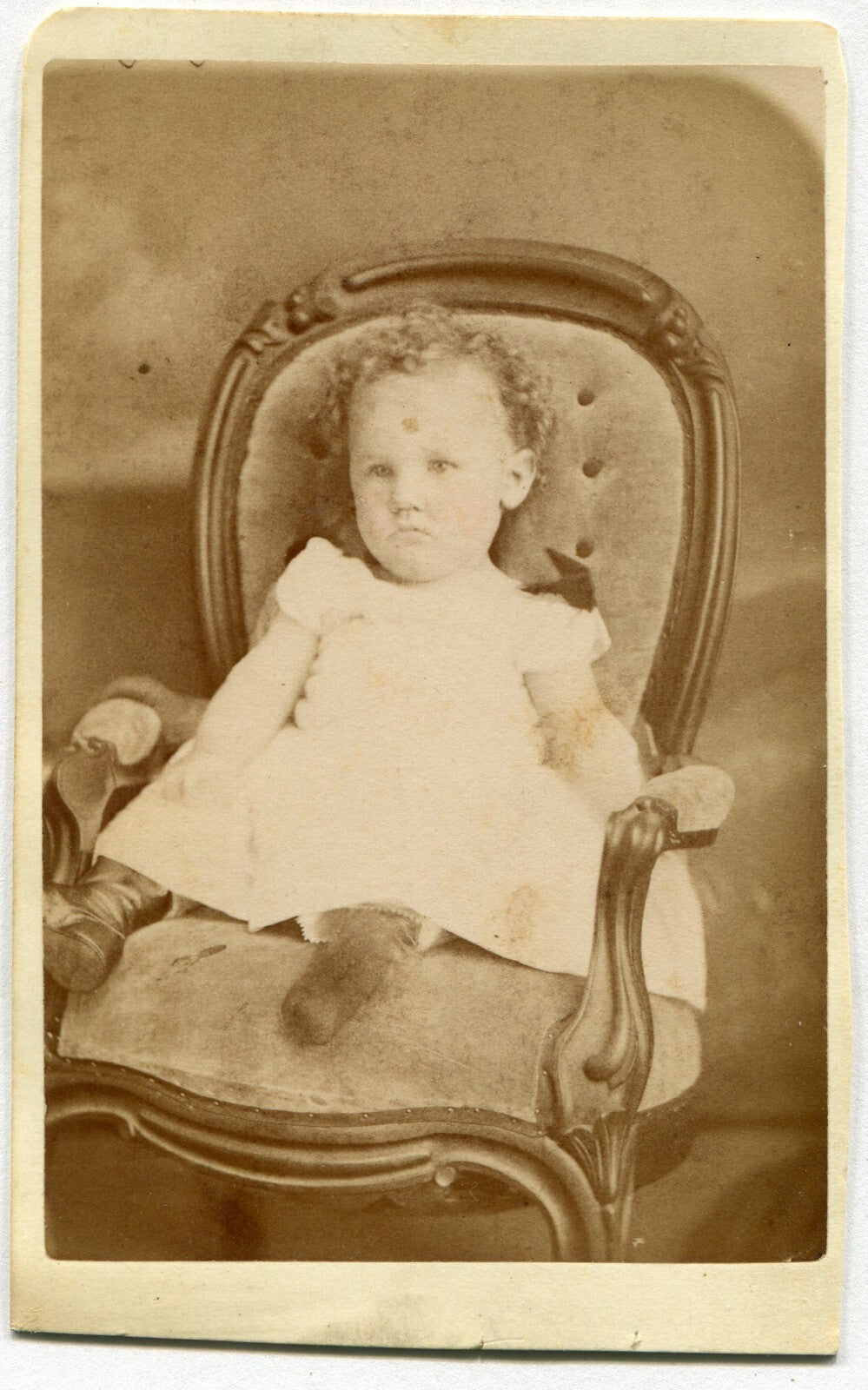 GRUMPY TODDLER SEATED ON ORNATE CHAIR. CDV. LEWISBURG, PA.