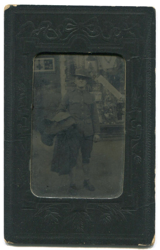 U.S. SOLDIER, FULL UNIFORM POSED IN FRONT OF STORE. TINTYPE IN PAPER MAT.